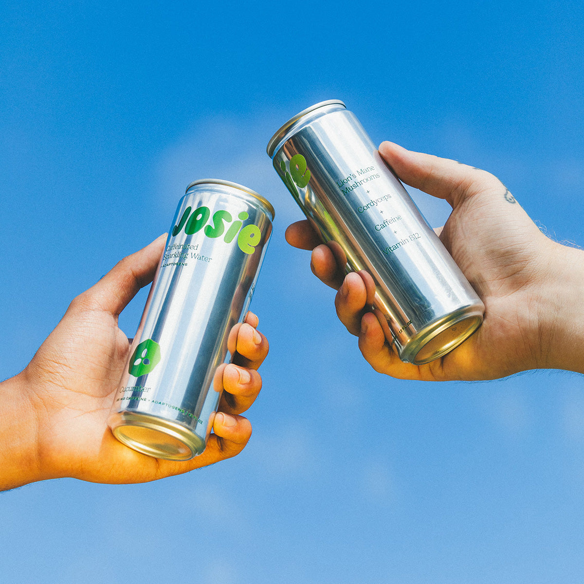 Two cans of Josie against a clear blue sky